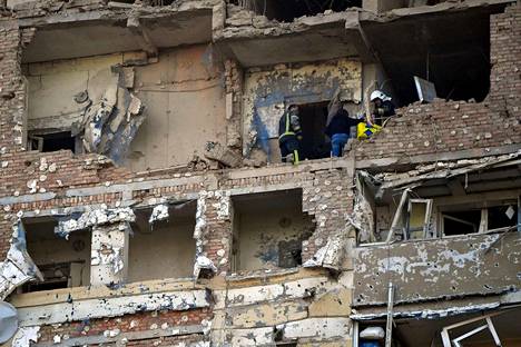 Pelastajat auttoivat naista poistumaan vaurioituneesta kerrostalosta Venäjän hyökättyä tiistain vastaisena yönä lennokein Ukrainan pääkaupunkiin Kiovaan. Isku oli kolmas 24 tunnin aikana.