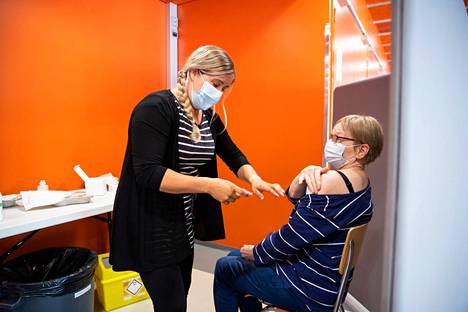 Anja Heiskanen sai neljännen rokotteen Euran urheilutalolla elokuussa. Veera Satola on kiireapulaisena rokottamassa.