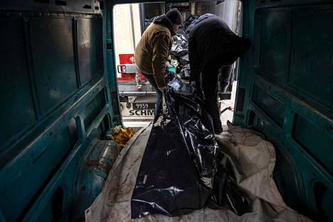 Ruumista kannetaan ulos pakettiautosta Butšan kaupungissa Kiovan alueella 12. huhtikuuta.