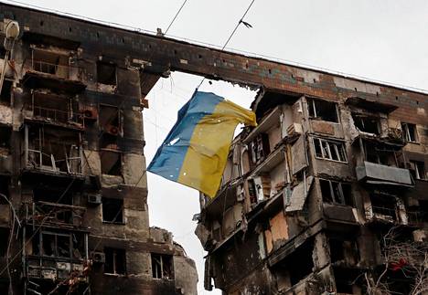 Ukrainan lippu liehui tuhoutuneen asuinkerrostalon edustalla Mariupolin kaupungissa.