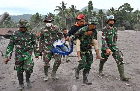 Pelastustyöntekijät kantavat turvaan Sumberwuluhin kylän asukasta Lumajangissa Semerun purkauksen jälkeen.