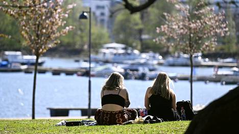 Ihmisiä istui auringonpaisteessa Helsingin Tokoinrannassa 16. toukokuuta.