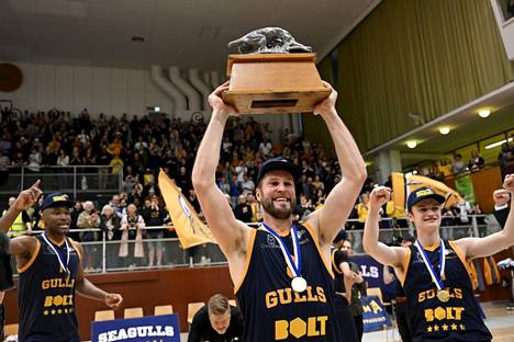 Timo Heinonen nostaa mestaruuspokaalia, kun Seagullsin pelaajat juhlivat koripallon miesten Korisliigan Suomen mestaruutta