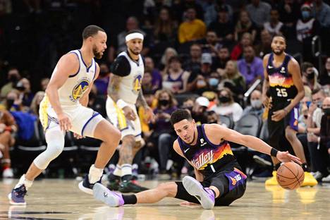 NBA-liigan joulupäivän ottelussa kohtasivat Golden State Warriors ja Phoenix Suns. Kuvassa Warriorsin Stephen Curry (vas.) ja Sunsin Devin Booker.