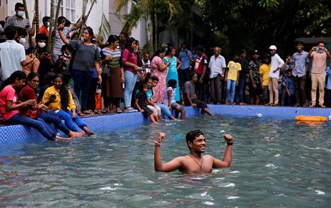 Kansaa presidentintalon uima-altaassa Sri Lankan Columbossa sunnuntaina 10. heinäkuuta 2022. Mielenosoittajat saapuivat joukolla entisen presidentin virka-asuntoon sunnuntaina. 