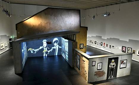 Banksy. A Visual Protest -näyttely avautuu lauantaina. Pulp Fiction -teoksen banaaneilla osoittelevat John Travolta ja Samuel L. Jackson riippuvat seinällä ja vilahtavat myös videoinstallaatiossa. 