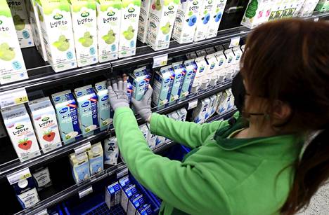 Työntekijä hyllytti maitotuotteita Helsingissä 4. helmikuuta 2021.
