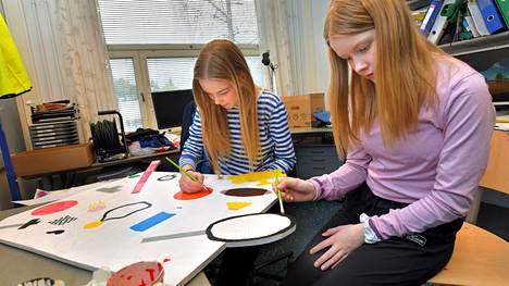 Enni Gahmberg (edessä) ja Helmi Katila maalasivat liikunta-aiheista kylttiä Pyörä-Nurmille. Ryhmän kolmas jäsen on Milena Teichmann. Yrittäjyyskasvatus on laaja-alainen osaamisalue, jossa yhdistyvät monet oppiaineet.