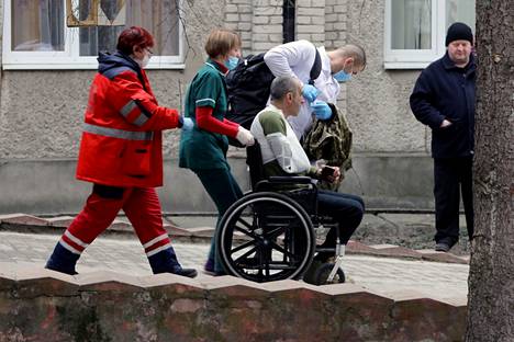 Pelastustyöntekijät siirsivät loukkaantunutta sotilasta sairaalaan Venäjän Javorivin sotilastukikohtaan tekemän ohjusiskun jäljiltä sunnuntaina.