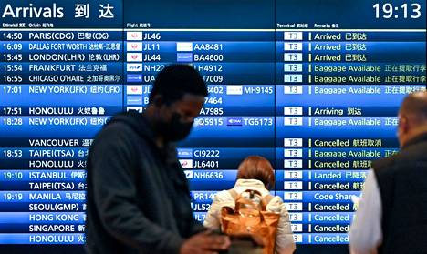 Ihmisiä seisoi saapuvien lentojen taulun edessä Japanissa Tokion Hanedan lentokentällä. Lentoja oli peruttu 30. marraskuuta Etelä-Afrikassa todetun omikronvariantin vuoksi. Japani sulki pian uutisten jälkeen rajansa ulkomaalaisilta matkailijoilta.
