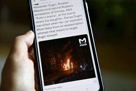 Kännykän ruudulla näkyy kuvakaappaus Twitter-julkaisusta, jonka kuva esittää Moskovan lauantaisen autopommi-iskun tuhoja. 