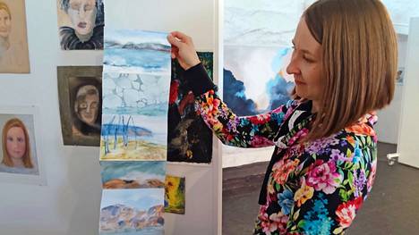 Suunnittelijaopettaja Inkeri Mikkilä esittelee kansalaisopiston kevätnäyttelyä. Hänen kädessään olevasta akvarellihaitarista muodostuu kokoon taitettuna pieni kirja.