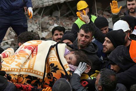 Pelastajat kantavat tyttöä ulos maanjäristyksessä romahtaneesta rakennuksesta Diyarbakirissa Turkissa.