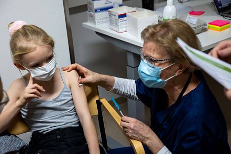 8-vuotias Mimmi Johansson sai maanantaina koronarokotuksen Hatanpäällä. Hoitaja Merja Koponen antoi rokotteen. Hän oli saapunut eläkkeeltään auttamaan korona­rokotuksissa.