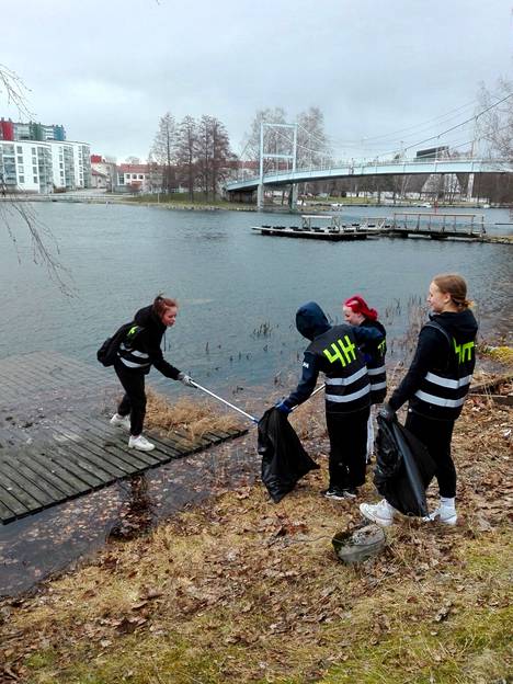 4H-nuoret Lilli Hänninen (vas.), Siiri Lauttajärvi, Vilma Saarela ja Sonja Salo noukkivat roskaa vedestä.