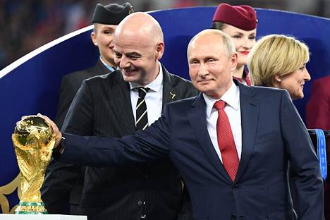 Fifan puheenjohtaja Gianni Infantino katselemassa, kuinka Venäjän presidentti Vladimir Putin koskettaa maailmanmestaruuspokaalia Venäjän MM-kisojen finaalissa neljä vuotta sitten.