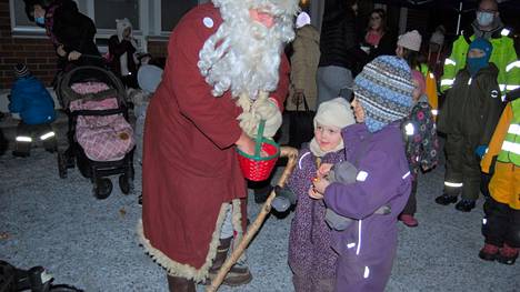 Kesken lahjakiireiden Merikarvian joulunavauksessa piipahtanut Joulupukki antoi karamellit Kerttu (kesk. kuvassa) ja Viljami Anttila-Känälle.