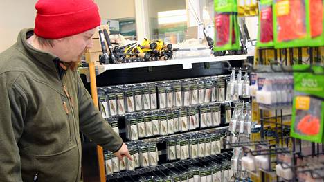 VK-Storen yrittäjä Jussi Koskinen esittelee kivijalkakaupan kalastusvälinevalikoimaa.