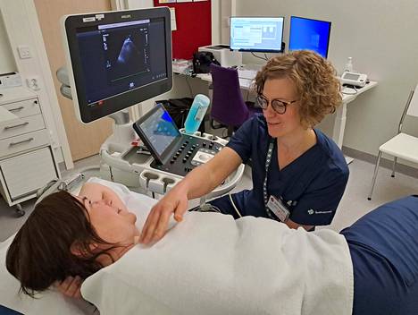 Sydänsairaalan sairaanhoitaja-sonograaferi Heidi Pekkanen valmistelee potilasta ultraäänitutkimukseen kardiologian poliklinikan vastaanottohuoneessa. 
