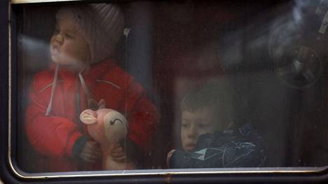 Ukrainasta paenneet lapset katsoivat junasta Puolan Przemyslin rautatieasemaa maanantaina 28. helmikuuta. 