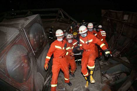 Pelastustyöntekijät kuljettavat hotellin romahduksessa loukkaantuneita ihmisiä Kiinan Quanzhoussa.