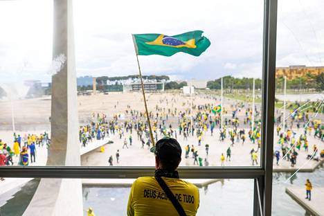 Mies heilutti Brasilian lippua, kun mielenosoittajat tulvivat kongressin ulkopuolelle. Mediatietojen mukaan mielenosoittajat päässeet sisälle parlamenttirakennukseen.
