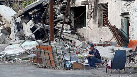 Mies istui tuhoutuneen talon edessä Mariupolissa, Ukrainan eteläisessä satamakaupungissa, jota on pommitettu ja saarrettu koko Venäjän hyökkäyksen ajan.