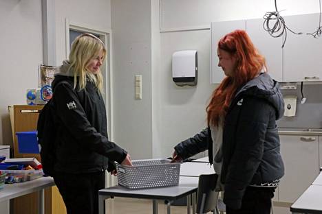 Veera Lamminpää (vas.) ja Aino Yli-Kovero nappaavat puhelimensa laatikosta oppitunnin päätteeksi. 