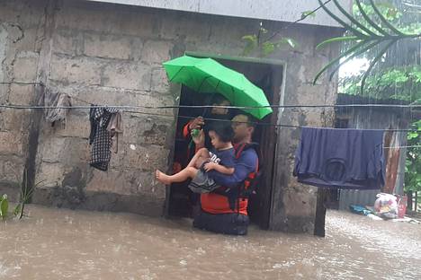 Pelastajat evakuoivat lasta tulva-alueella Ozamisin kaupungissa 25. joulukuuta.