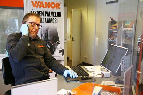 Yrittäjä Kari Vuokko otti vastaan puhelimitse renkaanvaihdon ajanvarauksia keskiviikkona aamupäivällä. Pärskesuojalla varustetun yrityksen palvelutiskillä käytetään myös kertakäyttöhanskoja.