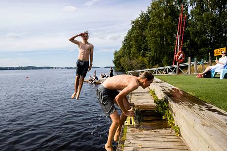 Wivi Lönnin koulun oppilaat Veikko Haustalo (vas.) ja Simo Riihelä pääsivät liikuntatunnilla rantalentiksen jälkeen hyppimään Pyhäjärveen vilvoittelemaan Tampereella 15.8.2022.