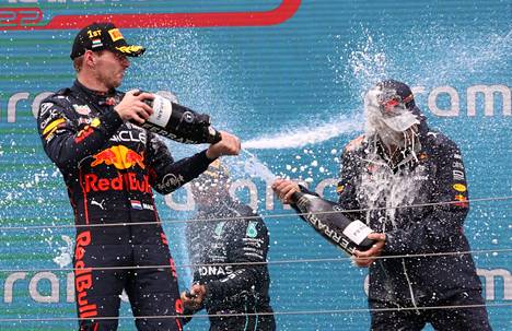 Max Verstappen pääsi juhlimaan podiumilla Unkarin F1-kisan voittoa, vieressä George Russell ja taustalla Lewis Hamilton.