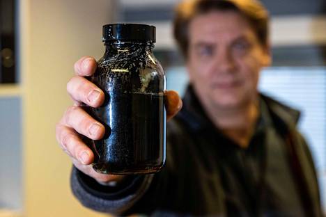Tero Joronen näyttää purkillista mustalipeästä tuotettua bioöljyä, jonka voisi edelleen jalostaa öljynjalostamoissa polttoaineiksi.