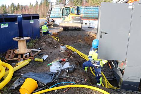 Voimatelin miehet Kimmo Miettinen ja Konsta Joukamaa rakentavat sähköauton latauspistettä Tuorilan Seon pihamaalla.