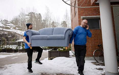 Jarkko Jokela kantaa sohvaa ja hoitaa samalla puhelimessa muita työasioita. Sohvan toisessa päässä Hude Huttunen.