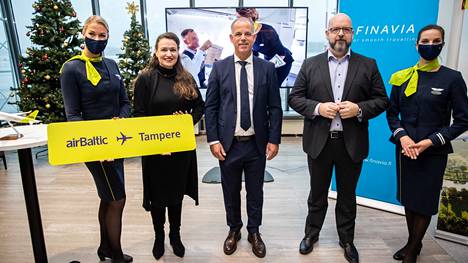 Pormestari Anna-Kaisa Ikonen (toinen vas.), Air Balticin toimitusjohtaja Martin Gauss ja Finavian verkostoliiketoiminnan johtaja Jani Jolkkonen asettuivat kuvaan Air Balticin henkilökunnan kanssa tiistaina.