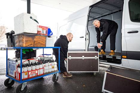  Kooveen jääkiekkojoukkueen varusteita pakattiin maanantaina Latvian-matkaa varten. Huoltopäällikkö Jari Saloniemi (vasemmalla) ja huoltaja Pentti Saloniemi kantamassa varusteita.