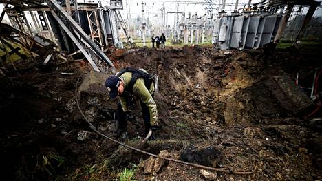 Tutkijat kävivät läpi Venäjän ilmaiskun aiheuttamaa kuoppaa harkovalaisella sähkölaitoksella 28. syyskuuta Ukrainassa.