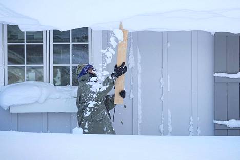 Talvimyrsky on kurittanut etenkin New Yorkin osavaltiota. Paikallinen mies yritti poistaa lunta talonsa katolta Buffalon alueella.