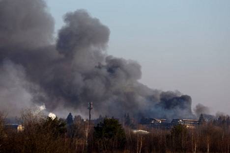 Kuvassa näkyy Lvivin lentokenttävarikon rakennuksesta nouseva savu perjantaiaamuna 18. maaliskuuta.
