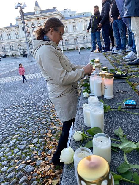 Tampereen evankelisluterilaisen seurakunnan yhteiskunnallisen työn diakoni Heidi Repo sytytti kynttilää Vanhan kirkon edustalla lauantaina.