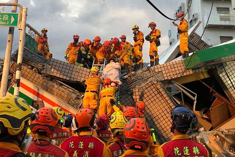 Pelastajat auttavat paikallista ihmistä pois maanjäristyksen aiheuttamista raunioista Yulin kaupungissa Hualienin alueella Taiwanissa. Kuva on peräisin Taitungin pelastuslaitokselta.