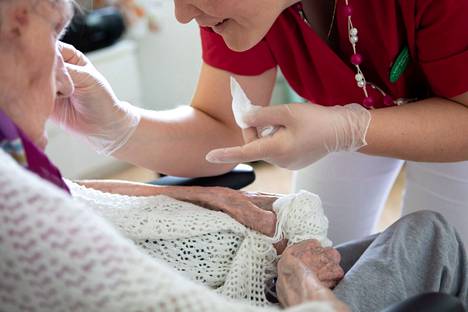 Lähihoitaja hoitamassa potilasta Espoossa 27. kesäkuuta 2019.