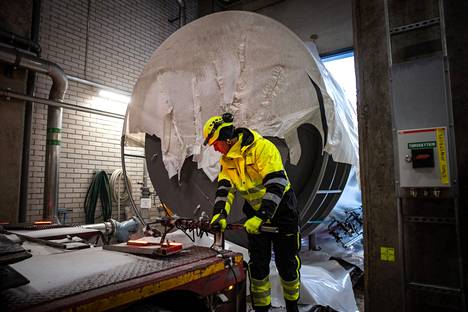 Sähkökattilan Etelä-Norjasta Tampereelle ajanut Patrik Öberg irrottaa lavetista kaiken irti lähtevän, jotta se saadaan vedettyä ulos hallista pois suuren kattilan alta.