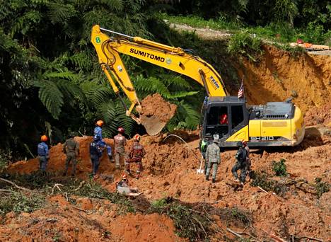 Pelastajat työskentelivät maanvyöryn jälkeen leirintäalueella Batang Kalissa Malesiassa 17. joulukuuta.