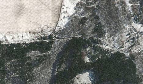 Satelliittikuvasta erottuu Venäjän armeijan kalustoa metsän reunassa. Ajoneuvoja näkyy rivissä kuvan oikeassa reunassa melko keskellä. Kuva on otettu torstaina.