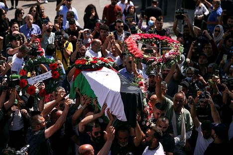 Shireen Abu Aklehin perhe ja ystävät kantoivat kuolleen toimittajan ruumista Länsirannalla 12. toukokuuta.