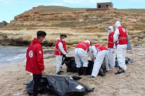 Yhden hukkuneista ruumista laitettiin pussiin Libyan rannikolla tiistaina 14. helmikuuta.