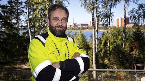 Teollisuuden voiman turvallisuuspäällikkö Veli-Pekka Nurmi uskoo, että suurimmat ongelmat on nyt voitettu, ja Olkiluoto 3 -ydinvoimala pääsee aloittamaan kaupallisen sähköntuotannon joulukuussa. Nurmen pään oikealla puolella häämöttävät kolmosreaktorin suojakupu ja ilmastointipiippu. Siitä oikealle ovat OL1- ja OL2-ydinvoimalayksiköt.