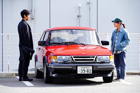 Yūsuke Kafuku (Hidetoshi Nishijima) ja Misaki Watarin (Tôko Miura) lähtevät ajamaan Saabilla elokuvassa Drive My Car.